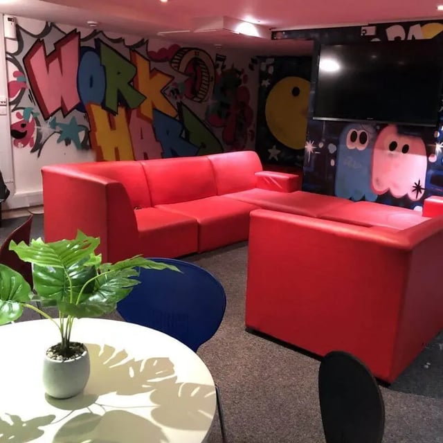 Red couches graffiti artwork and television living room at Horton House Bradford in Bradford Student Accommodation