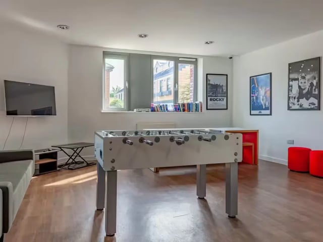 Foosball table television couch and posters living room at Central Studios - London in London Student Accommodation