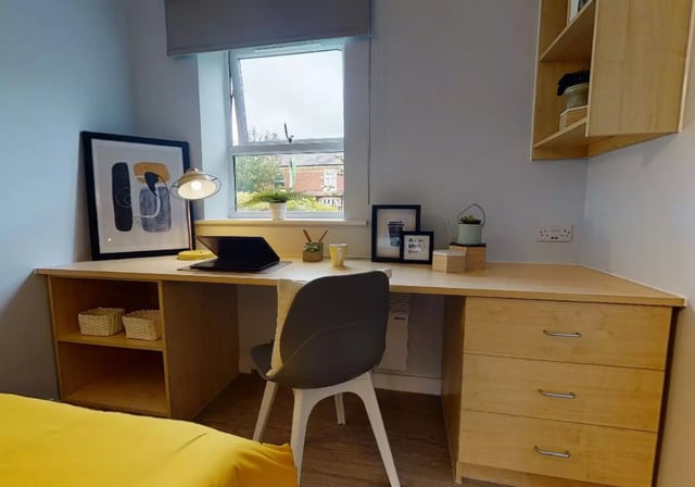 Desk with laptop artwork and chair bedroom at iQ Student Quarter in Salford Student Accommodation