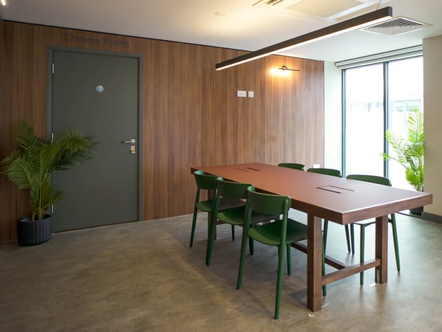 Brown table green chairs large window common room at Straits Garden in Egham Student Accommodation