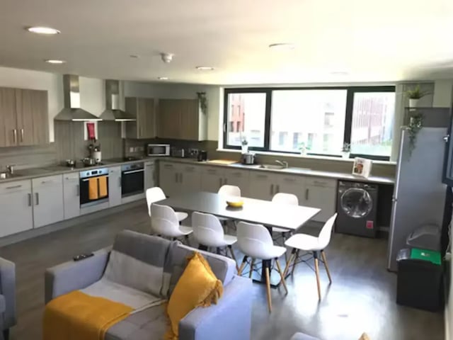 Kitchen with dining table and lounge area at Hollis Croft in Sheffield Student Accommodation