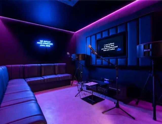 Lounge, TV, microphones, neon sign entertainment room at Hollis Croft in Sheffield Student Accommodation