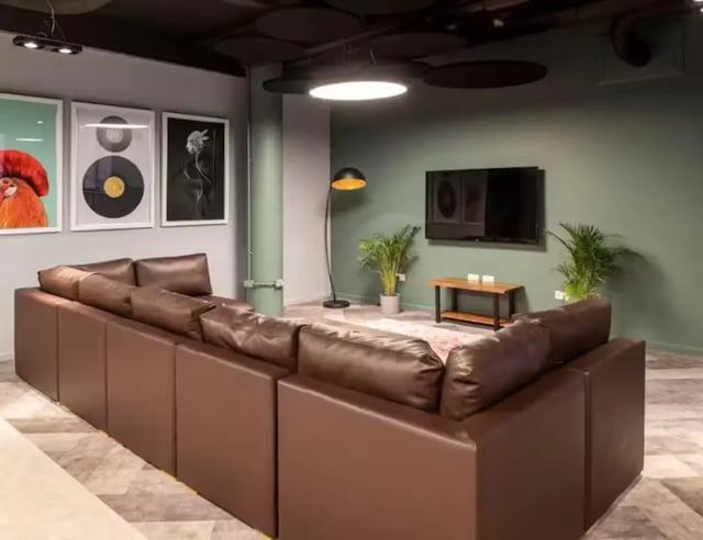 Brown sectional sofa artwork television plants living room at Hollis Croft in Sheffield Student Accommodation