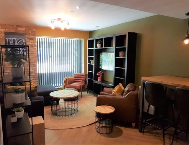 Modern living room with couches bookshelf and table. Living room at St James Point in Newcastle Upon Tyne Student Accommodation
