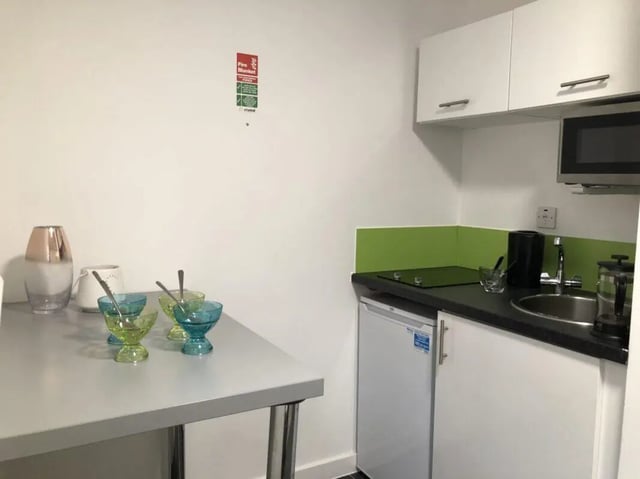 Table with bowls and mini kitchen kitchen at Tudor Studios in Leicester Student Accommodation