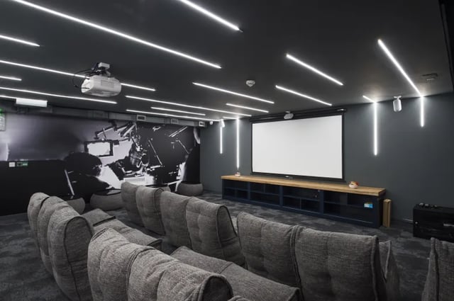 Beanbag chairs facing projector screen and mural playing area at Riverside Quay in Stirling Student Accommodation
