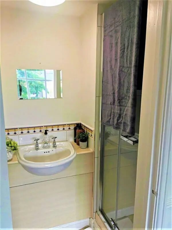 Sink mirror shower curtain tiled splashback bathroom at Highgate in Leicester Student Accommodation