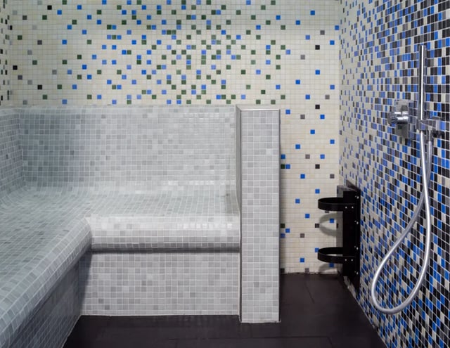 Tiled steam room with shower and bench bathroom at The Glassworks - Leeds in Leeds Student Accommodation