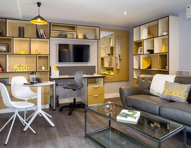 Sofa shelves desk chairs coffee table living room at The Glassworks - Leeds in Leeds Student Accommodation
