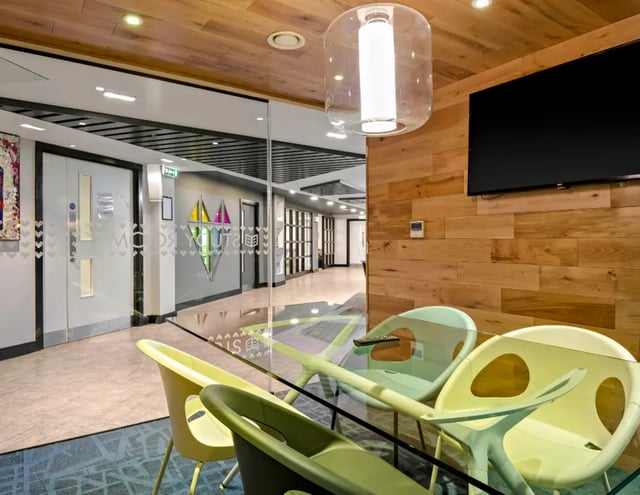 Glass table with chairs and TV common area at Iconinc The Triangle in Leeds Student Accommodation