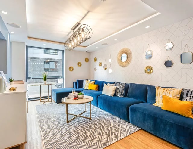 Blue sectional sofa patterned rug living room at Iconinc The Triangle in Leeds Student Accommodation