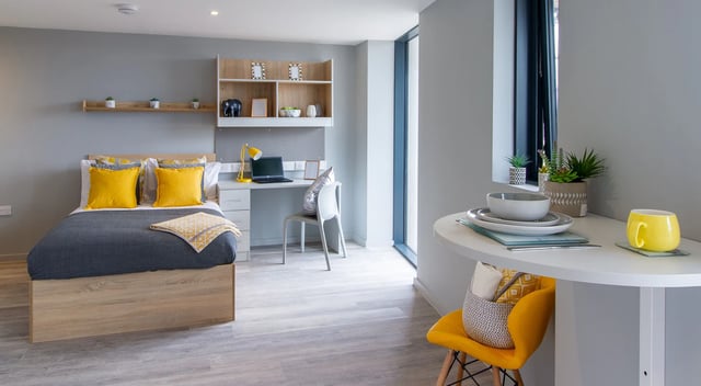 Bed desk shelves table yellow accents student studio at Renslade House in Exeter Student Accommodation