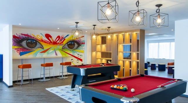 Pool tables graffiti artwork bar stools seating area recreation room at Renslade House in Exeter Student Accommodation
