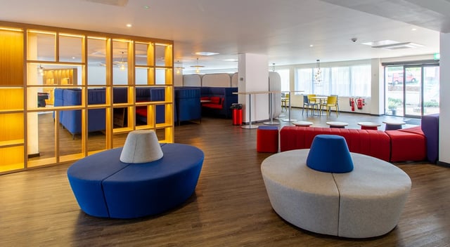 Modern lounge with blue seating and red sofas communal area at Renslade House in Exeter Student Accommodation