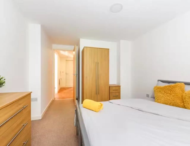 Wooden dresser bed with yellow pillows and wardrobe bedroom at Mellor House - Central Place in Sheffield Student Accommodation
