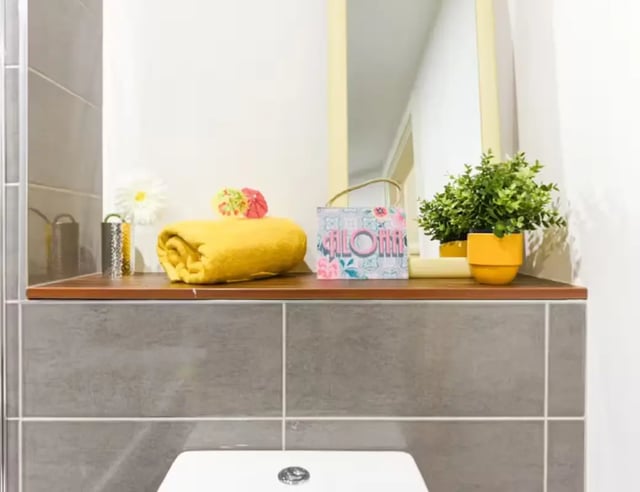 Yellow towel plant and decorative items bathroom at Mellor House - Central Place in Sheffield Student Accommodation