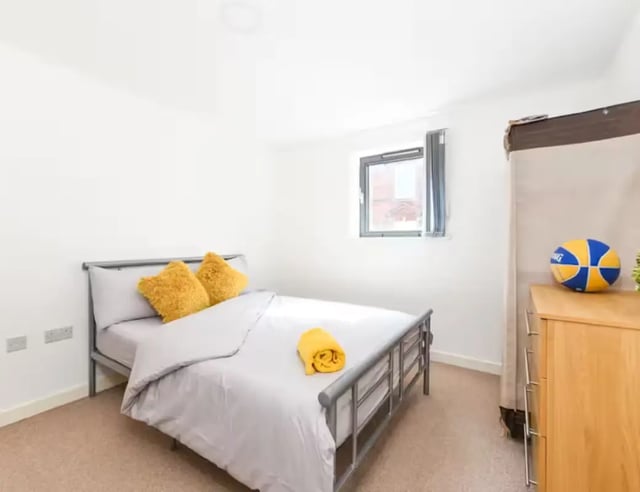 Bed with yellow pillows window dresser basketball bedroom at Mellor House - Central Place in Sheffield Student Accommodation