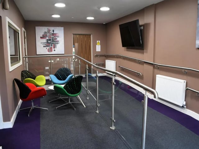 Colorful chairs glass railing mounted TV lounge area at Pembroke Studios in Liverpool Student Accommodation
