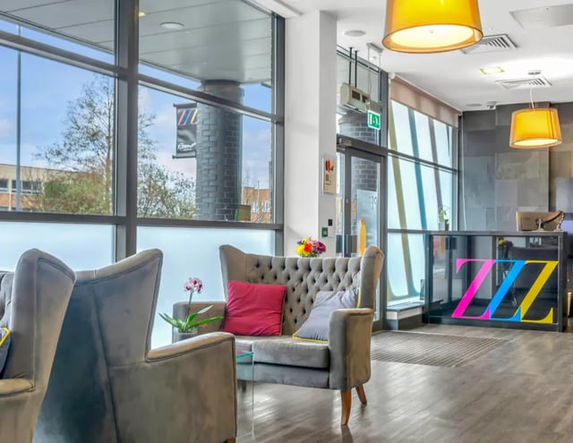 Sofa armchair reception desk ZZ logo lobby area at Iconinc Leeds City West in Leeds Student Accommodation