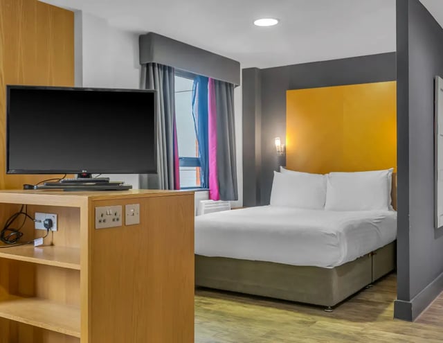 Television bed yellow headboard bedroom at Iconinc Leeds City West in Leeds Student Accommodation