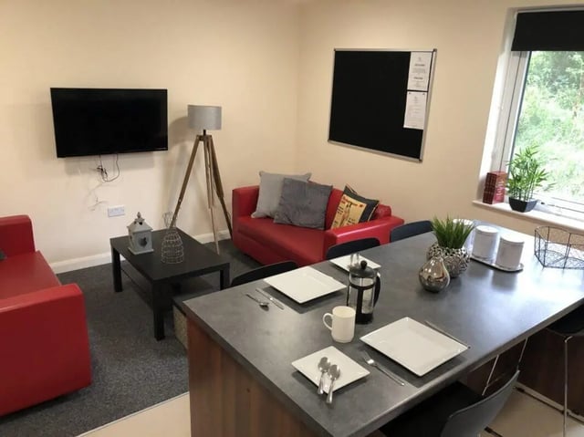 Red sofa television lamp black table living room at Jubilee Court in Preston Student Accommodation