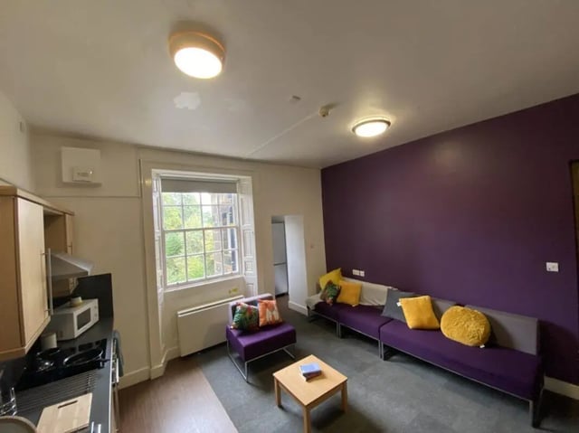 Kitchen microwave sofas pillows coffee table living room at Jubilee Court in Preston Student Accommodation