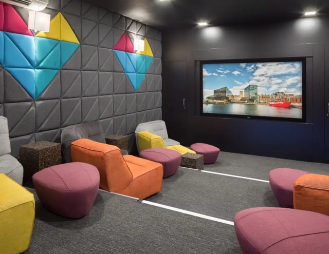 Colorful seating and screen in a lounge area at The Ascent in Liverpool Student Accommodation