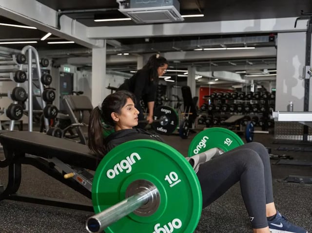 Woman exercising with weights gym equipment. at Powis Place in Aberdeen Student Accommodation