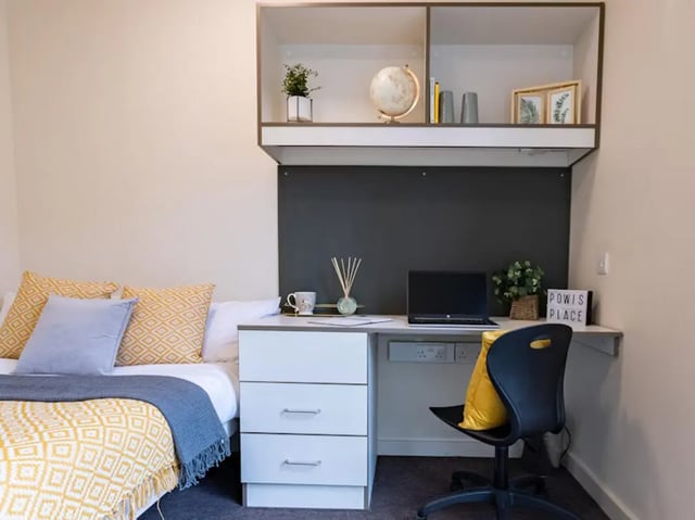 Bed desk chair pillows and shelving unit bedroom at Powis Place in Aberdeen Student Accommodation