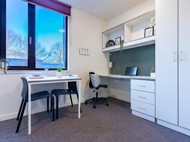 Table chairs desk laptop shelves wardrobe study area at Powis Place in Aberdeen Student Accommodation
