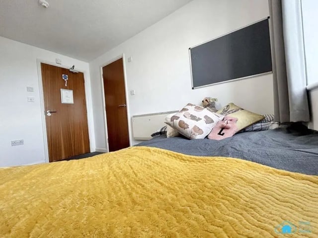 Bed with yellow blanket and pillows Bedroom at Rochester Student Village in Rochester Student Accommodation