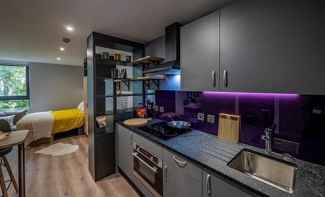 Modern grey kitchen with cooking hob and bed at Carters Yard in Stirling Student Accommodation