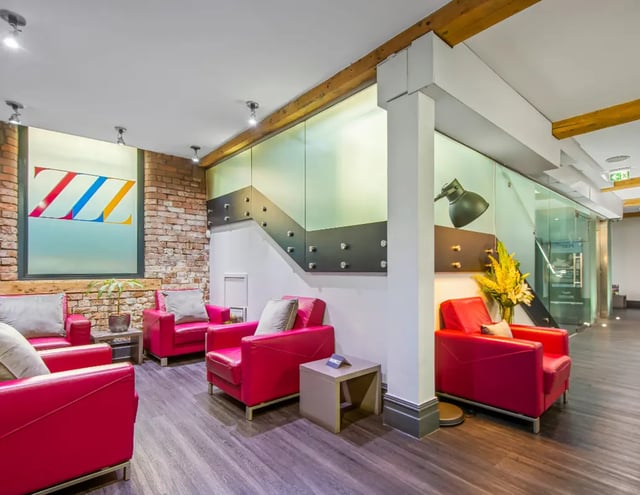 Bright red armchairs with grey cushions lobby at IconInc Manchester City in Manchester Student Accommodation
