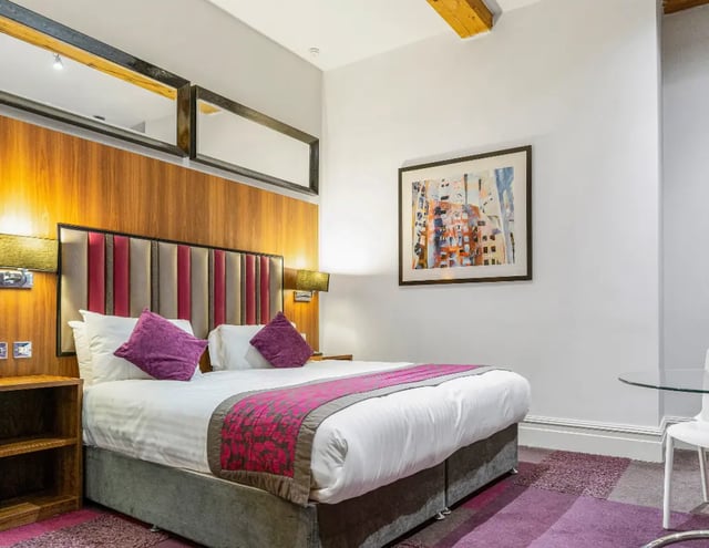 Bed with purple cushions and artwork Bedroom at IconInc Manchester City in Manchester Student Accommodation