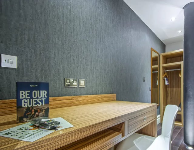 Desk with brochures and closet with mirror study area at IconInc Manchester City in Manchester Student Accommodation