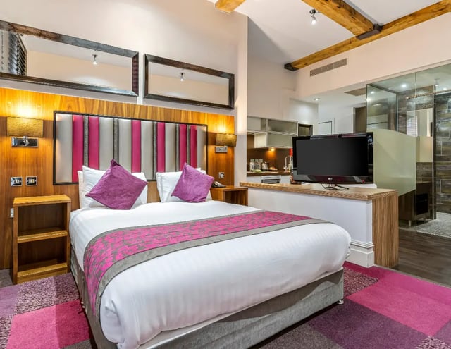 Double bed with purple pillows and pink throw bedroom at IconInc Manchester City in Manchester Student Accommodation