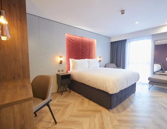 Bed with white linens bedside table chair Bedroom at IconInc York City in York Student Accommodation