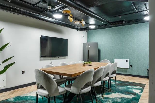 Large table with chairs television and refrigerator common room at Boutique Student Living Swansea in Swansea Student Accommodation