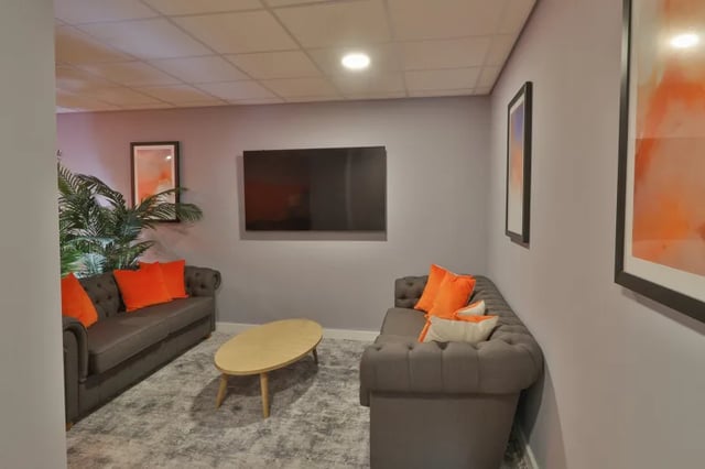 Two grey couches orange pillows oval coffee table living room at Boutique Student Living Swansea in Swansea Student Accommodation