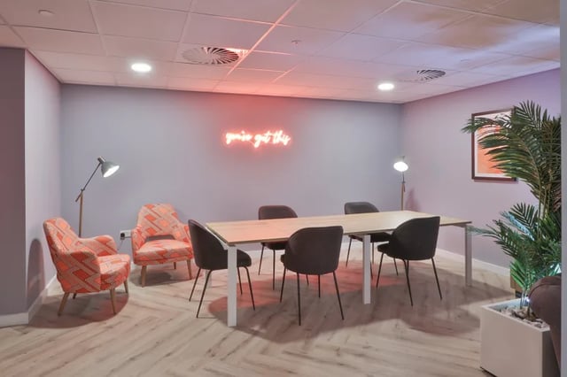 Table chairs lamps neon sign living room at Boutique Student Living Swansea in Swansea Student Accommodation