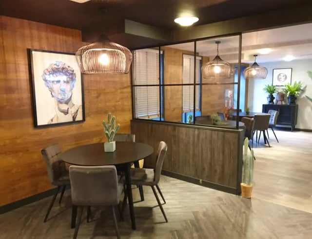 Round table, chairs, art, plants common area at St James House in Newcastle Upon Tyne Student Accommodation