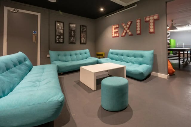 Turquoise sofas white table EXIT sign living room at Plato House in Liverpool Student Accommodation
