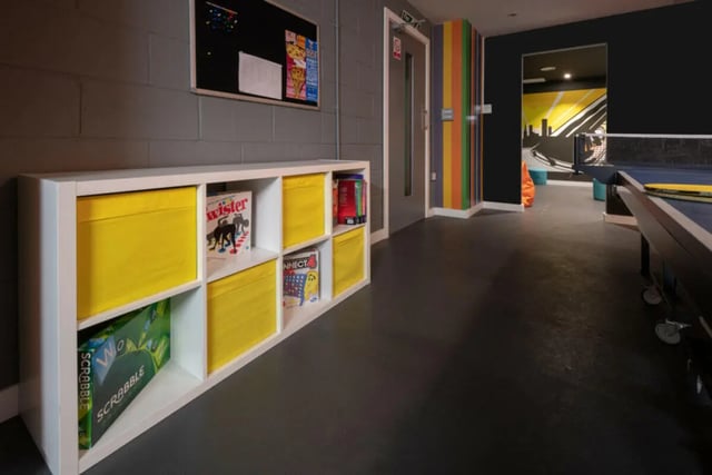 Storage unit with games and yellow bins common area at Plato House in Liverpool Student Accommodation