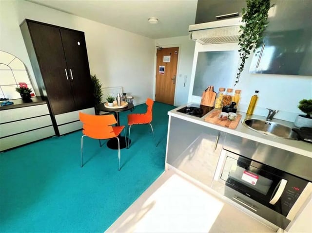 Wardrobe table chairs and kitchen area studio apartment at Plato House in Liverpool Student Accommodation