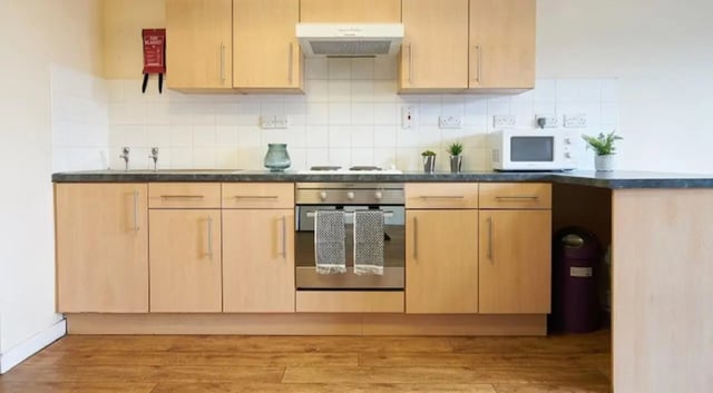 Kitchen with light wood cabinets microwave and oven Kitchen at Rockingham House in Sheffield Student Accommodation