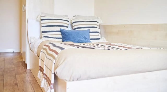Bed with striped pillows and throw bedroom at Rockingham House in Sheffield Student Accommodation