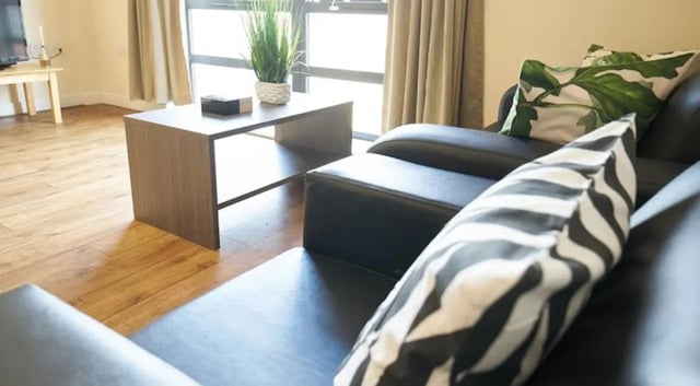 Black sofa with patterned cushions living room at Rockingham House in Sheffield Student Accommodation