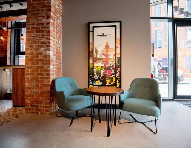 Two teal chairs round table artwork Common area at IconInc Newcastle City in Newcastle Upon Tyne Student Accommodation