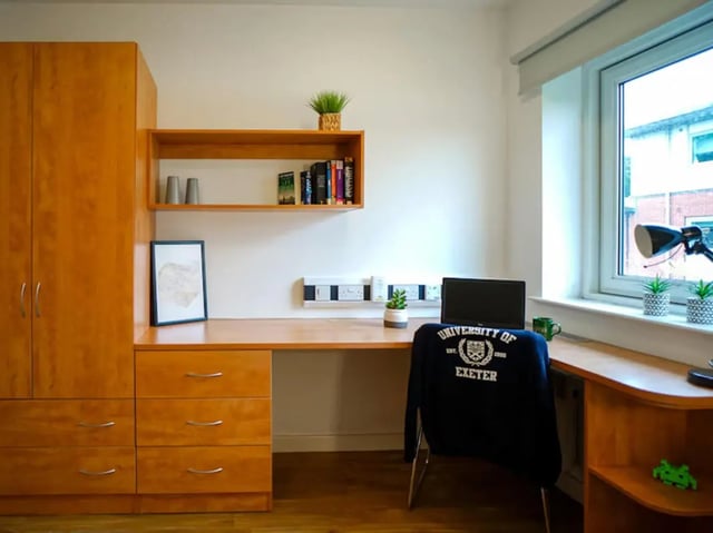 Wooden wardrobe desk chair laptop shelf study area at Exeter One in Exeter Student Accommodation