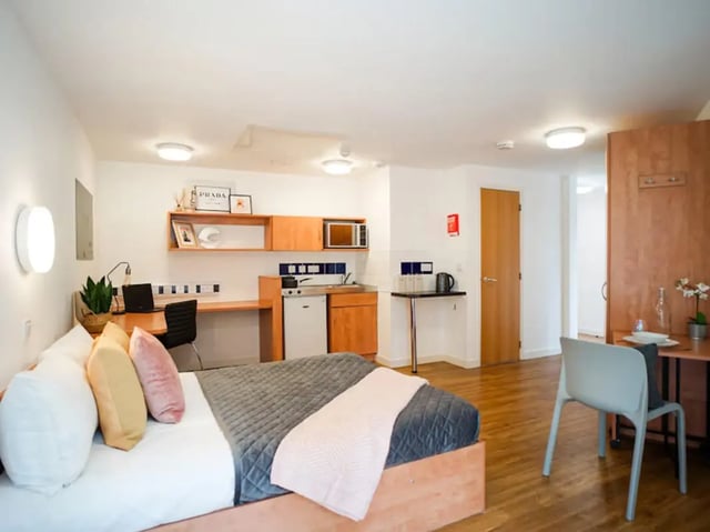 Bed desk kitchenette wooden cabinets studio apartment at Exeter One in Exeter Student Accommodation